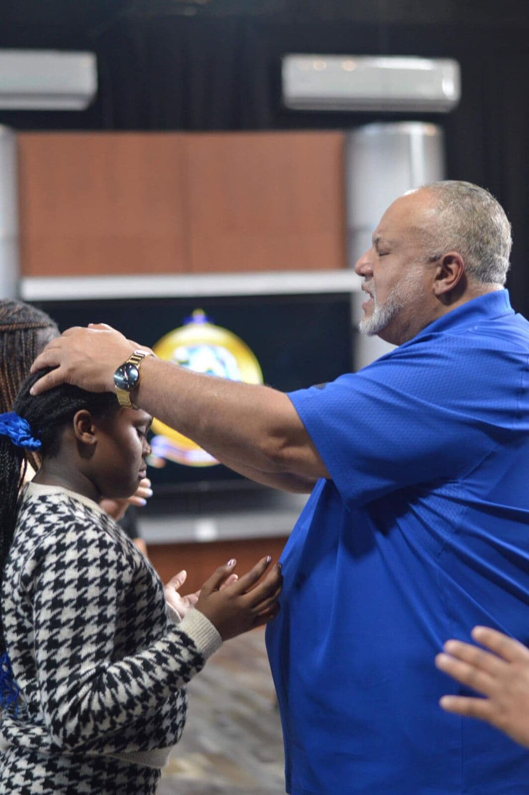 Pastor John H. Boyd II praying over a member